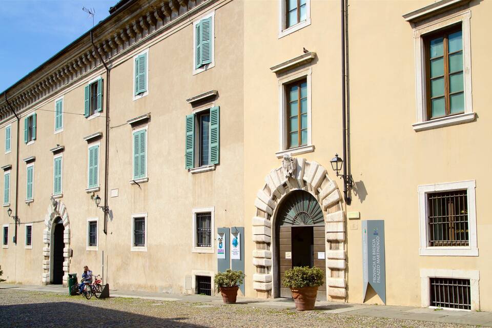 Ein historisches Gebäude mit grünen Fensterläden und einem steinernen Bogen.
