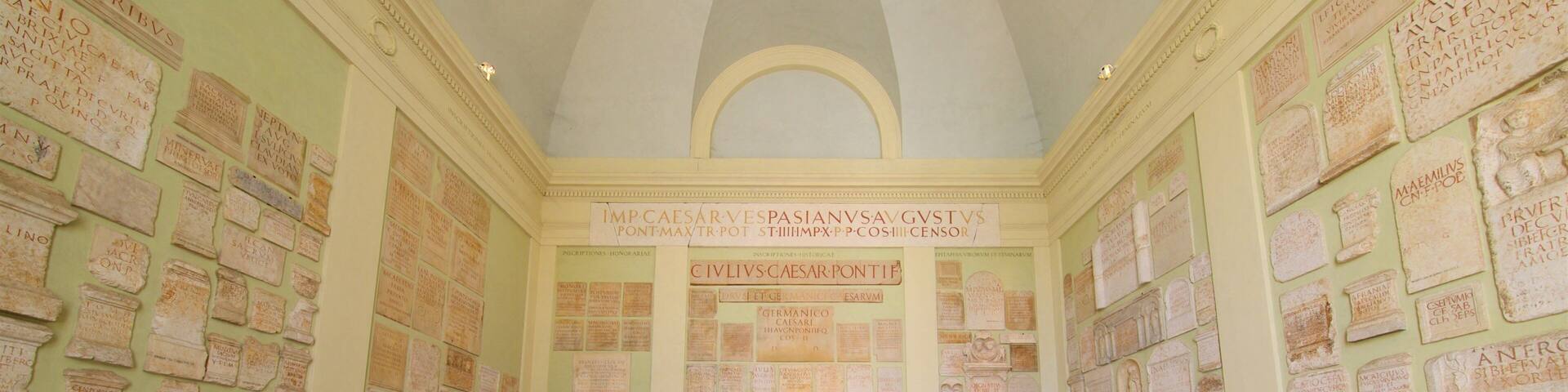 A room with stone inscriptions on the walls and large stone blocks in the center.