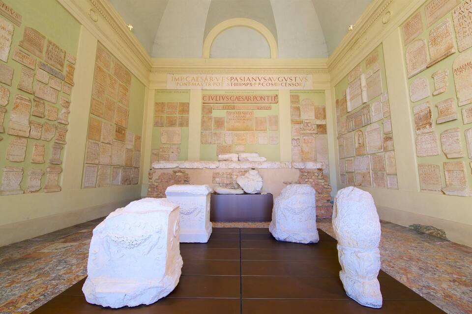 A room with stone inscriptions on the walls and large stone blocks in the center.