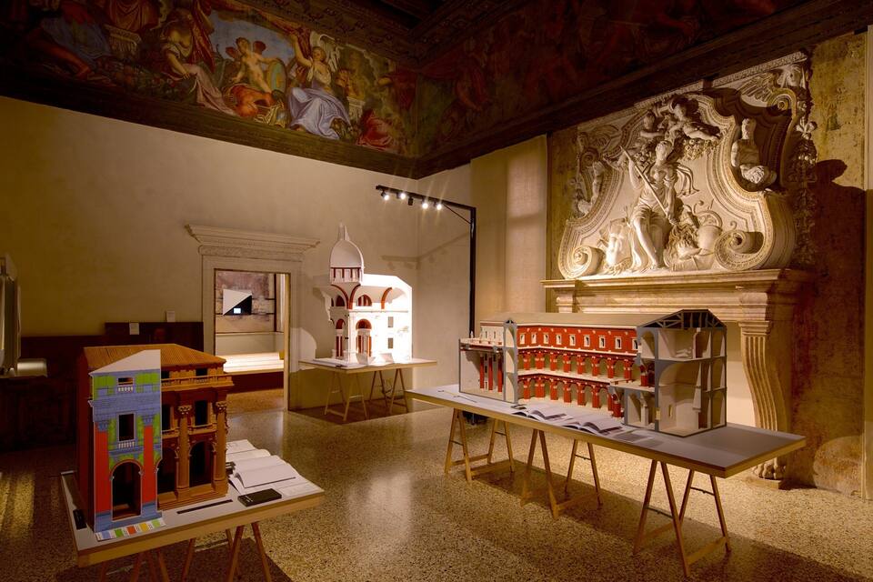 A museum interior with architectural models, a fresco, and classical sculptures.