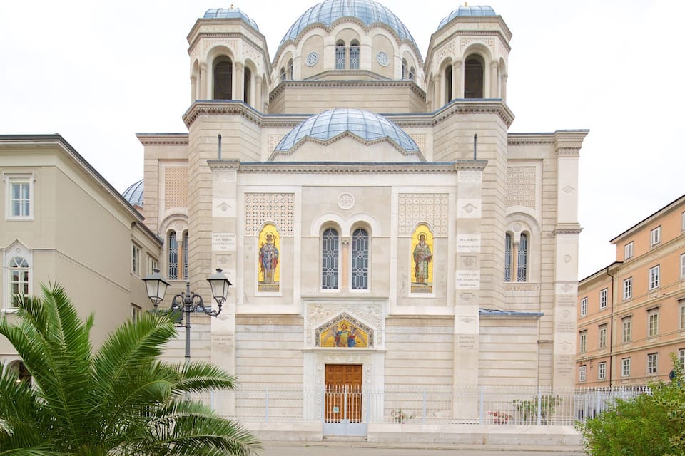 A historic church with a central dome, arched windows, and statues.