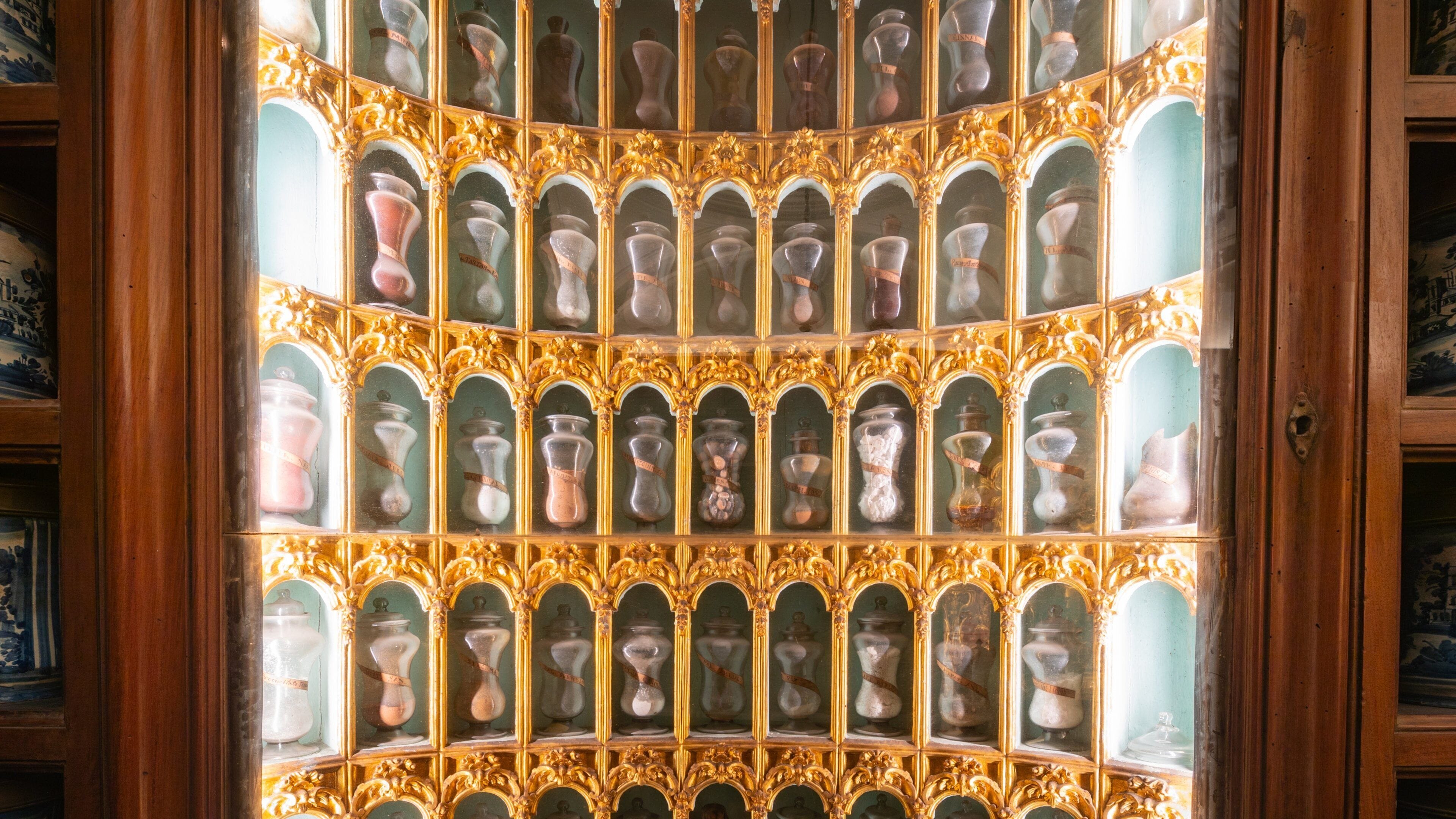 A display of ornate glass jars with gold frames, arranged in a symmetrical pattern.
