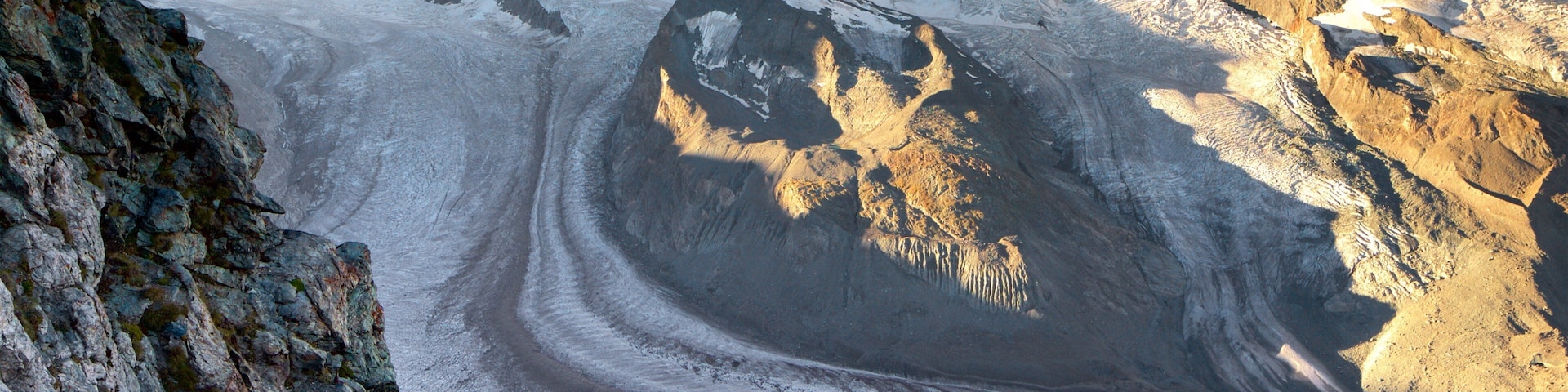 Um glaciar com uma fenda e terreno rochoso.