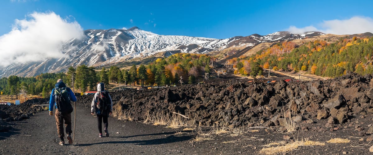 Panoramic view of northern side of Mount Etna, Sicily, with hikers walking on a lavic path