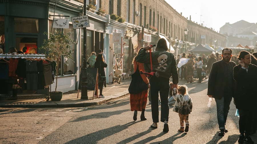 Columbia Road Flower Market featuring a sunset and street scenes as well as a family