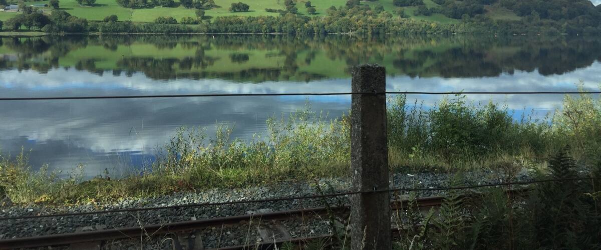 A lake reflecting the sky and surrounding hills.