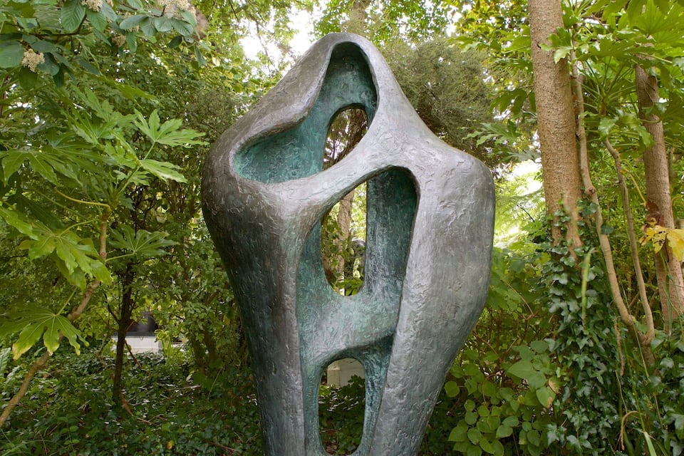 A large abstract sculpture in a forested area.