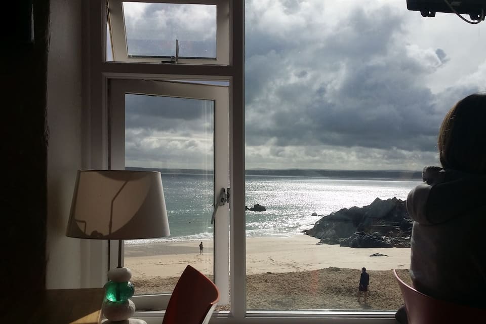 Vista d'una platja amb formacions rocoses i un cel nuvolós.