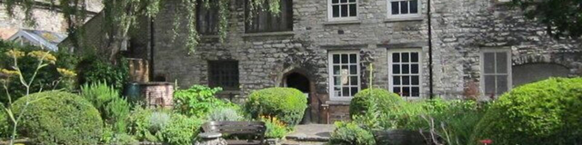 A stone building with a garden in front.