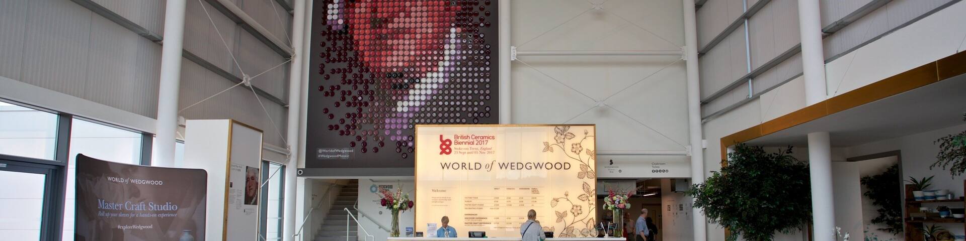 A large indoor exhibition space with a prominent display of a mosaic portrait.