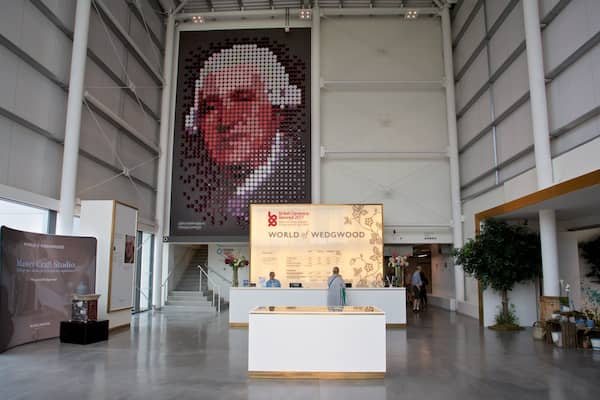 A large indoor exhibition space with a prominent display of a mosaic portrait.