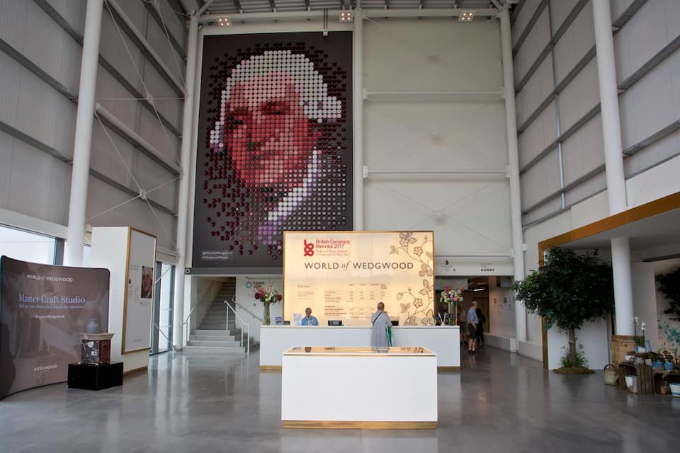 Amplo espaço de exposição interior com destaque para um retrato em mosaico.