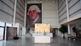 A large indoor exhibition space with a prominent display of a mosaic portrait.