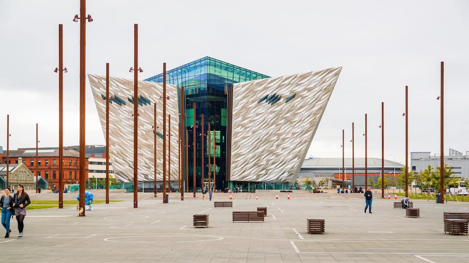 A modern building with a unique geometric facade and tall vertical poles.