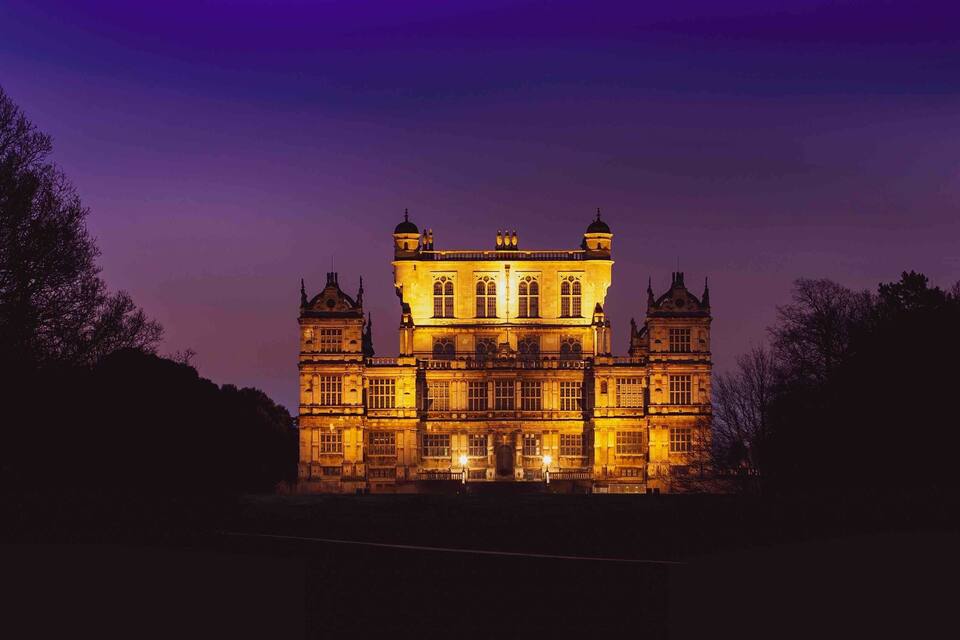 A grand, illuminated castle at dusk.