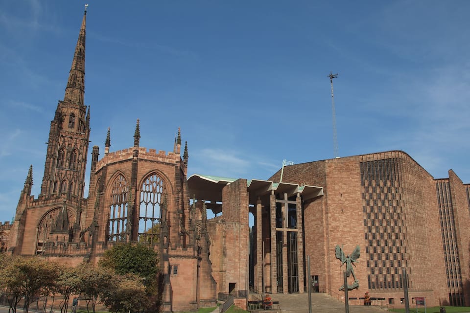 A historic church with a tall spire and a modern annex.