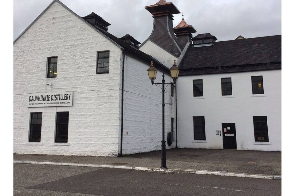 A white building with a sign reading "Dalwhinnie Distillery."