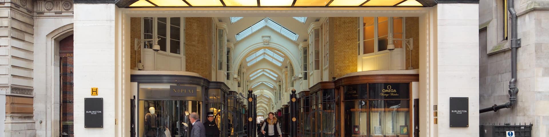 The entrance to Burlington Arcade with a grand archway and glass doors.