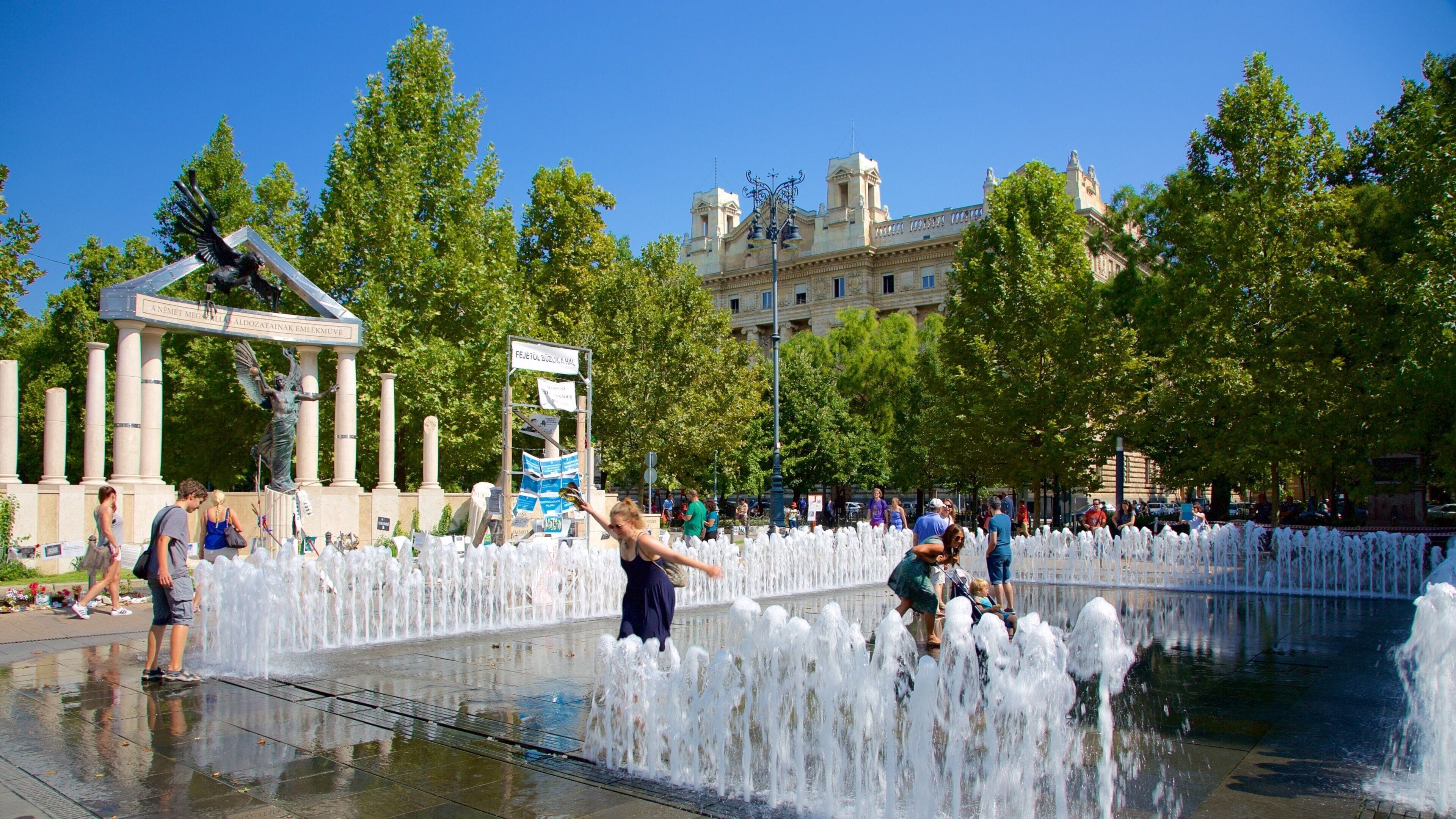 Budapest showing a fountain as well as a small group of people