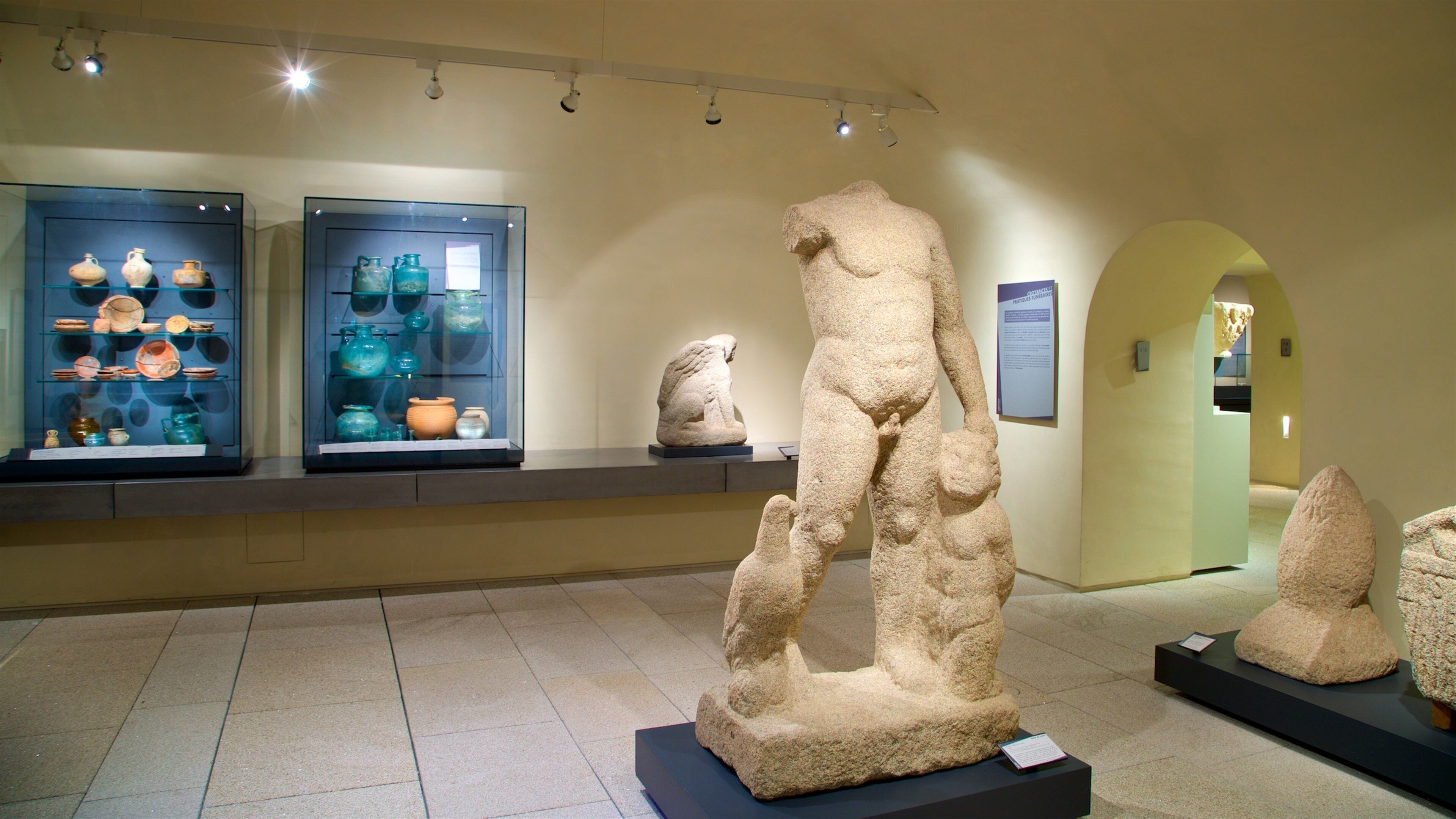 A museum exhibit with ancient pottery and stone sculptures.