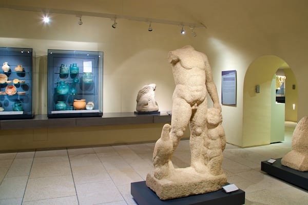A museum exhibit with ancient pottery and stone sculptures.