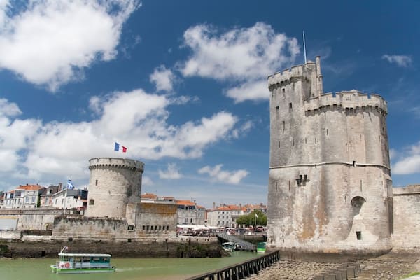 D046A4 A water taxi exiting between the twin towers of the Vieux Port or old harbour in La Rochelle