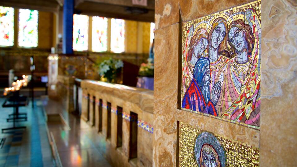 A church interior with stained glass windows and a mosaic.