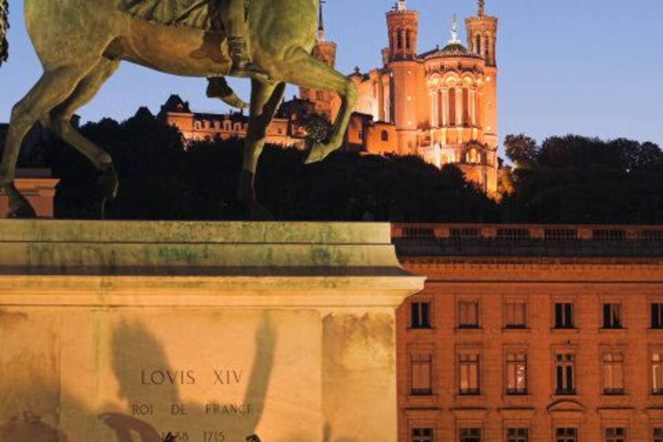 A statue of a man on a horse, a building with a cross, and a plaque reading "LOVIS XIV ROI DE FRANCE 1715".