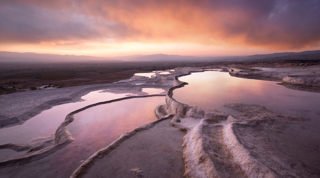 Beautiful sunset and Natural travertine pools and terraces in Pamukkale. Cotton castle in southwestern Turkey near Denizli, Hot springs white colored with turquoise blue water used like a bath