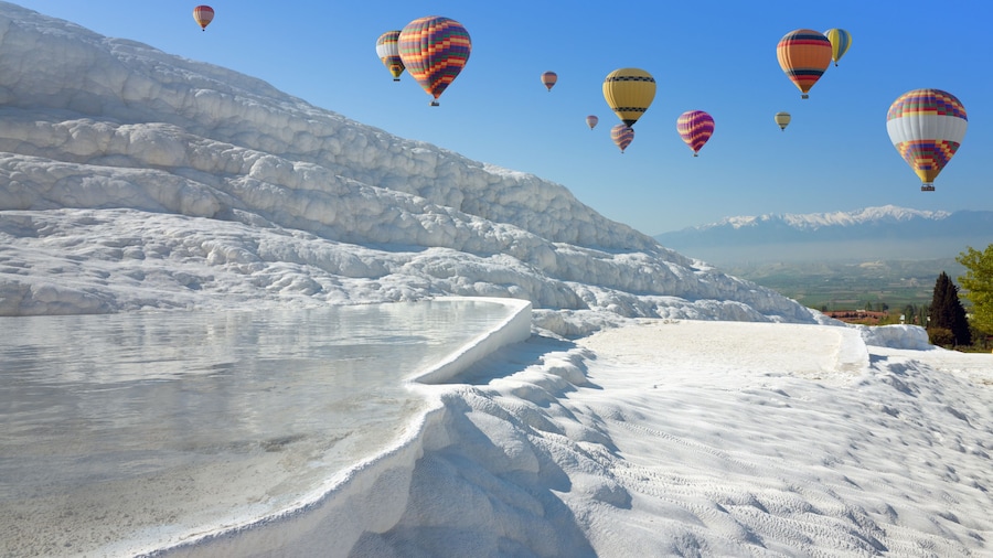 Hot air ballons flying above white Pamukkale, Turkey