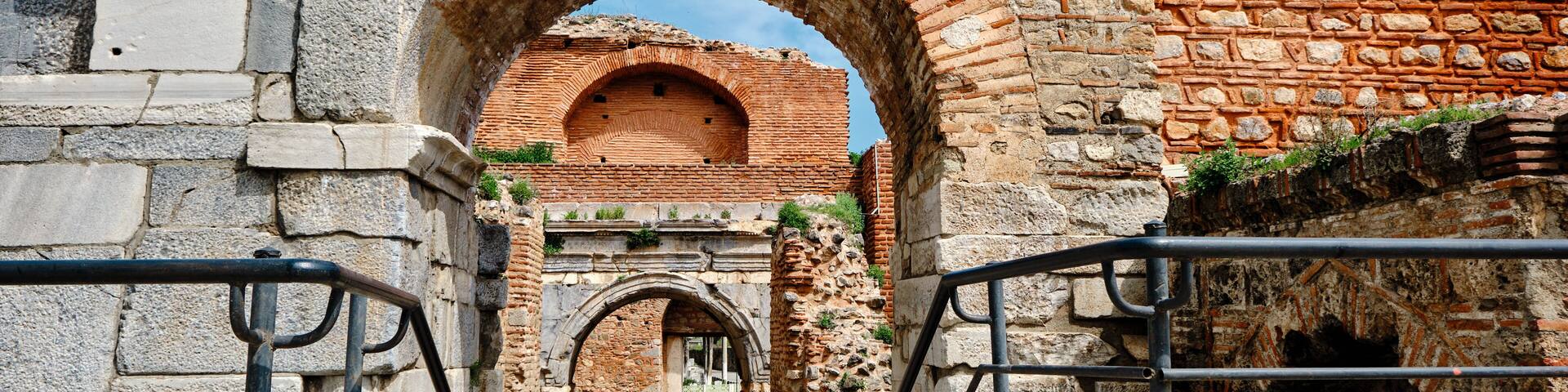 An ancient stone archway leading to a brick structure.