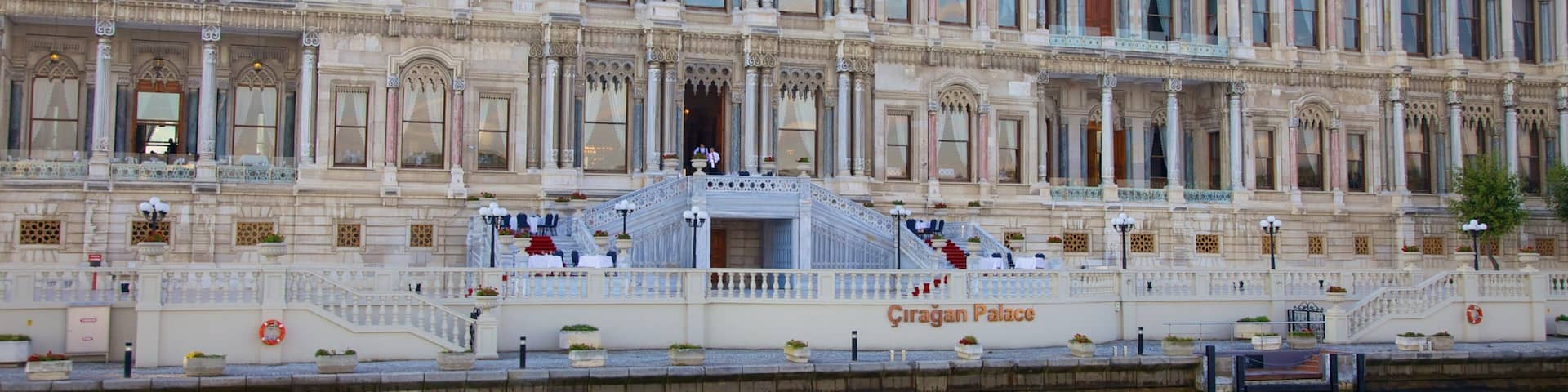 The Çırağan Palace with ornate architecture and a grand staircase leading to the entrance.