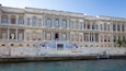 The Çırağan Palace with ornate architecture and a grand staircase leading to the entrance.