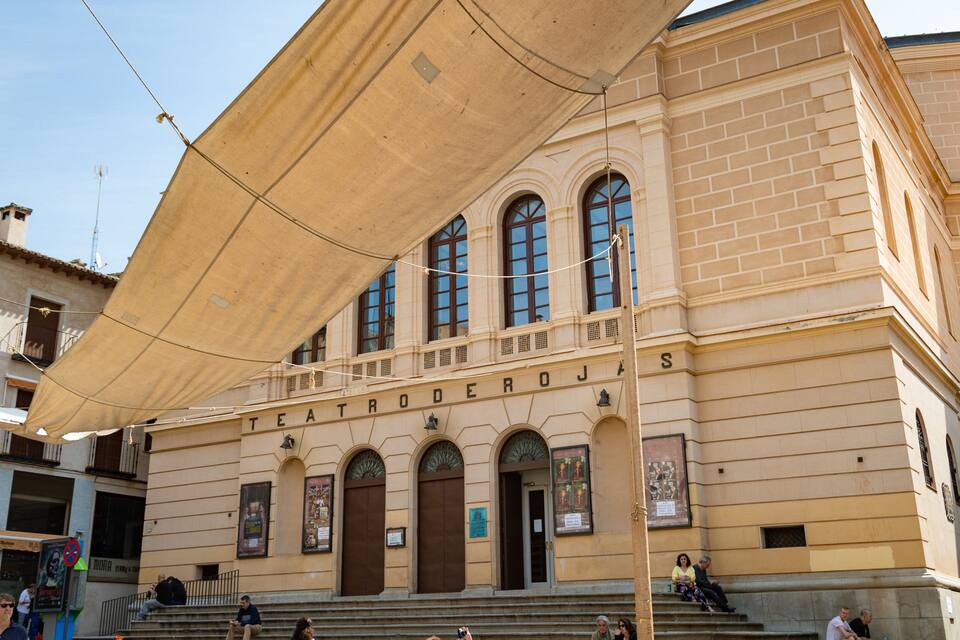 Un edificio histórico de teatro con ventanas en arco y un letrero que dice