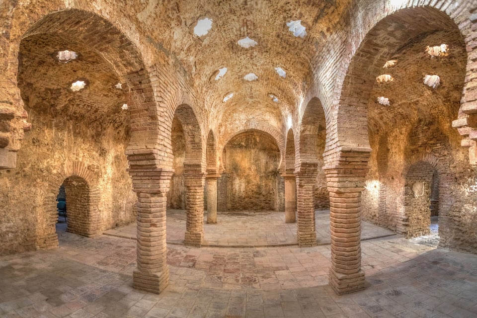 An ancient stone structure with arched ceilings and columns.
