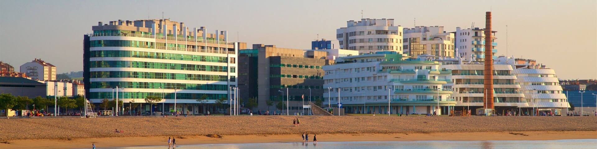 A coastal cityscape with modern buildings and a sandy beach.
