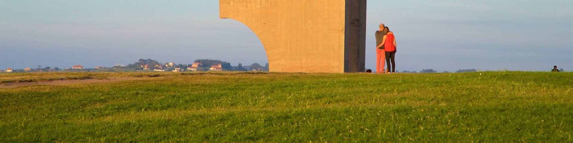 Una gran estructura de hormigón con forma de 'T' en un campo cubierto de césped bajo un cielo despejado.