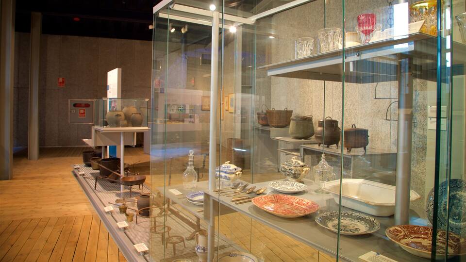 Eine Museumsvitrine mit historischem Küchengeschirr und Gebrauchsgegenständen.