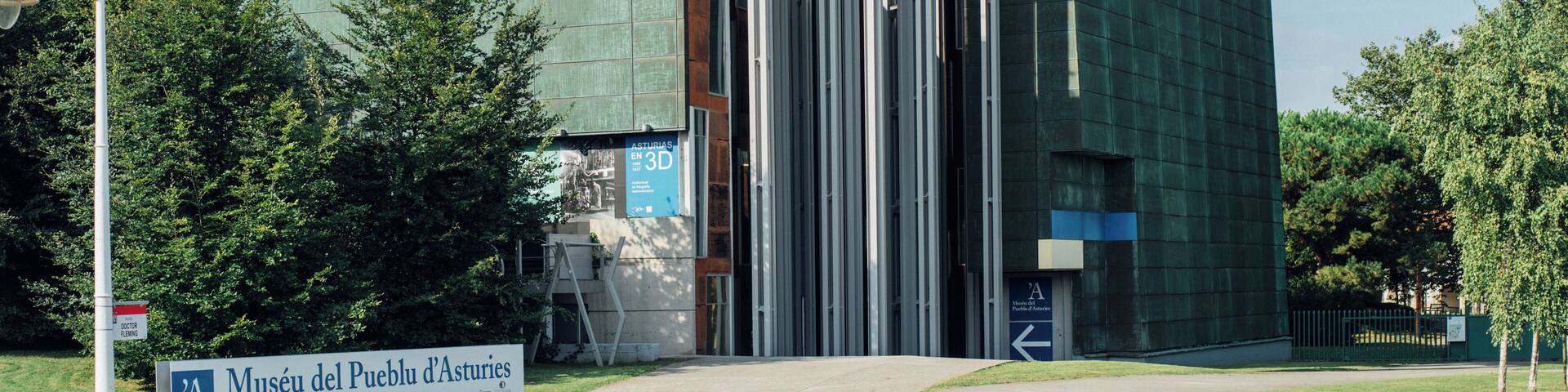 A modern building with a sign reading "Museu del Pueblu d'Asturies".