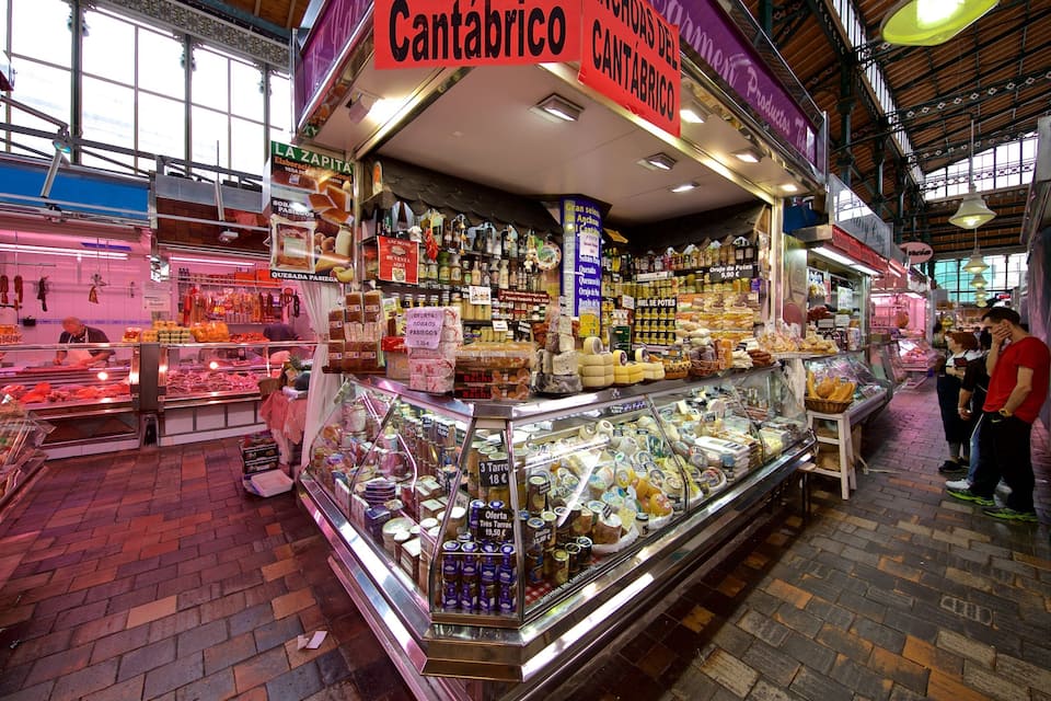 A market with a Cantabrico sign, various food items, and a brick floor.