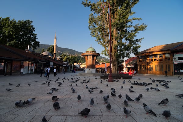 Sebilj in Sarajevo. View at the main square in the city center of Sarajevo (Baščaršija) full with pigeons early in the morning. Fountain in the middle and Baščaršijska džamija (mosque) at the back.