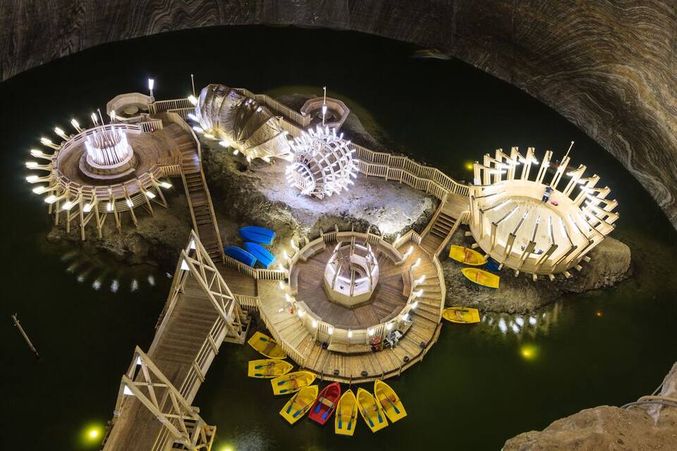 Una gran estructura acuática iluminada, con pasarelas de madera y barcos.