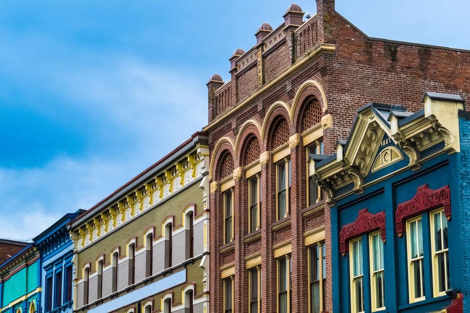 A row of colorful historic buildings with distinct architectural styles, including arched windows and decorative brickwork.