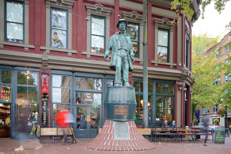 Una estatua frente a un edificio con ventanas amplias y un letrero que dice 'SIX ACRES'.