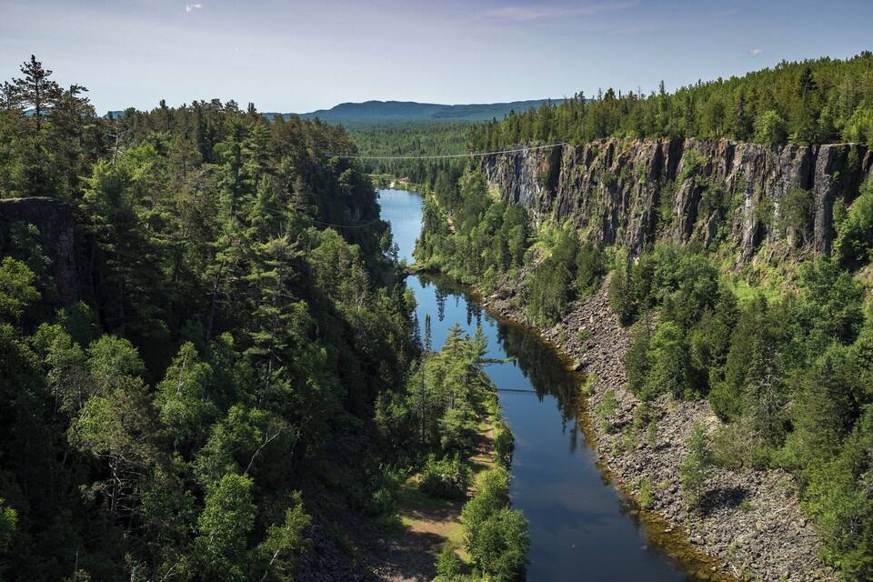 A river winding through a forested gorge with steep cliffs.