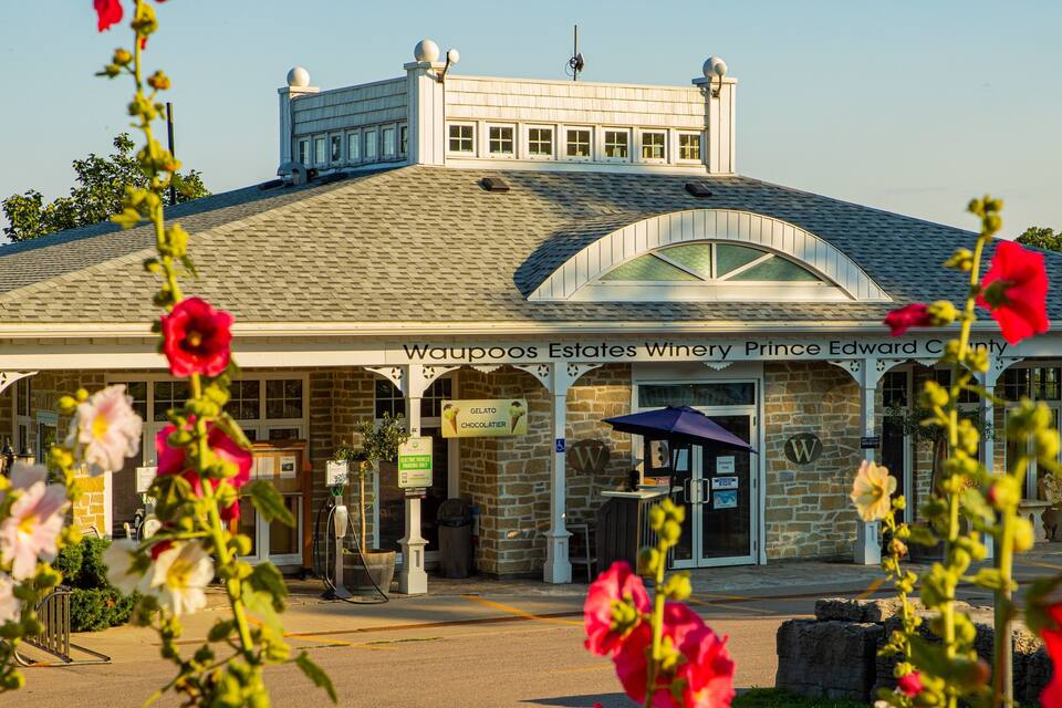 Un edificio con fachada de piedra y un letrero que dice "Waupoos Estates Winery Prince Edward County".