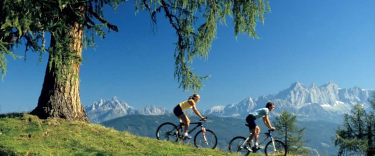 Austria, Salzburger Land, couple mountain biking, side view