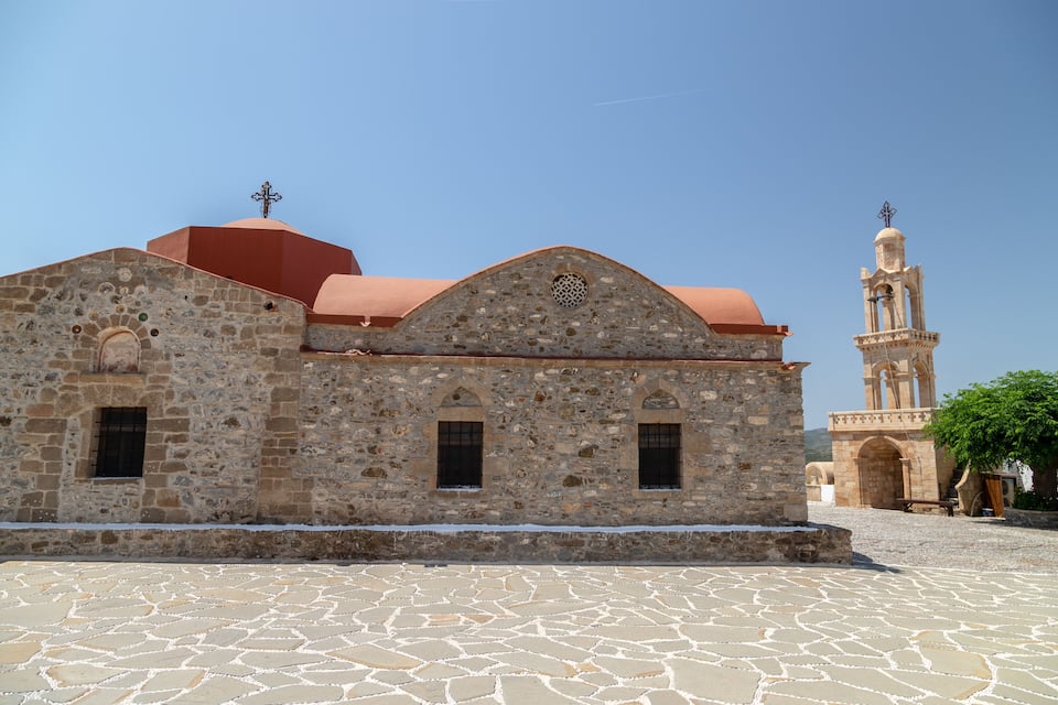 Una chiesa in pietra con tetto rosso e campanile.