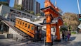 A vintage train station with an orange facade and a staircase leading up to it.