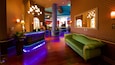 A lobby with a reception desk, a green sofa, and a large mirror.
